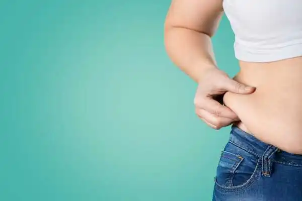 Image of woman pinching her love handles to show weight gain Shropshire